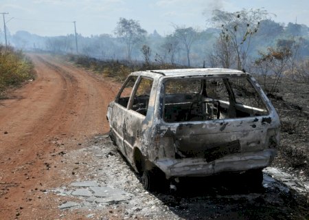 Carro fica destruído em incêndio e fogo se alastra na vegetação