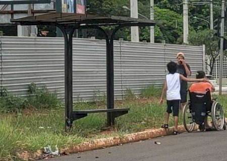 Sem cal&ccedil;ada rebaixada, cadeirante espera &ocirc;nibus na beira da rua